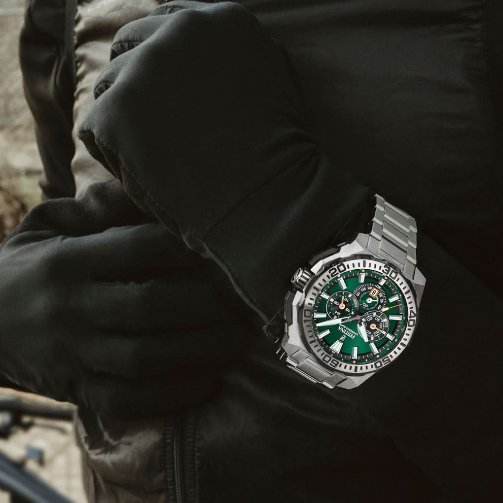 Herrklocka på handleden med grön urtavla och armband i rostfritt stål