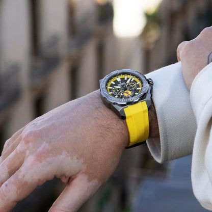 Herrklocka i kronografstil på handleden med gult armband och svart urtavla