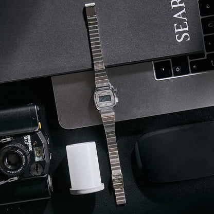 Casio damklocka med silverfärgat metallarmband och liten LCD-display, sidovy