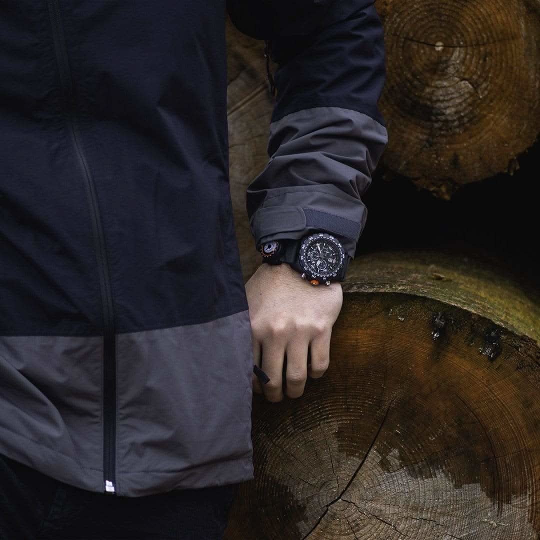 Herrarmbandsur på handleden med mörkt fodral och svart armband