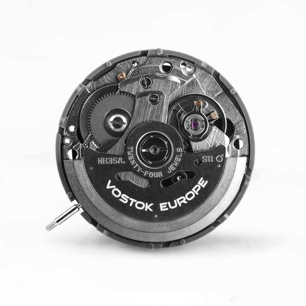 Baksidan av urverksdetalj, svart mekanisk platta med VOSTOK EUROPE-tryck