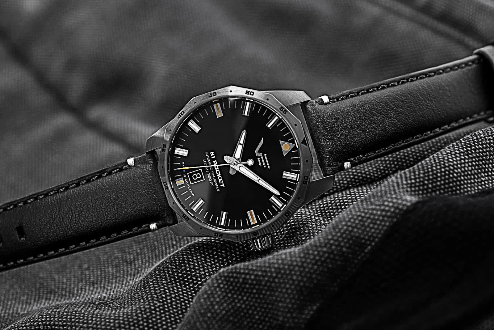 Unisex-armbandsur med svart urtavla och svart läderarmband, sidovy