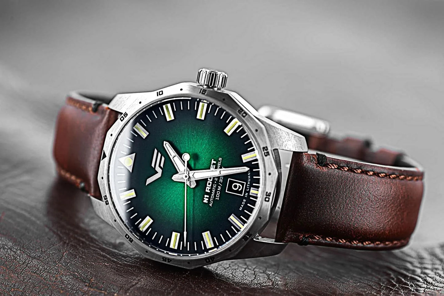 Herrklocka med brunt läderarmband och runt boett, grön urtavla