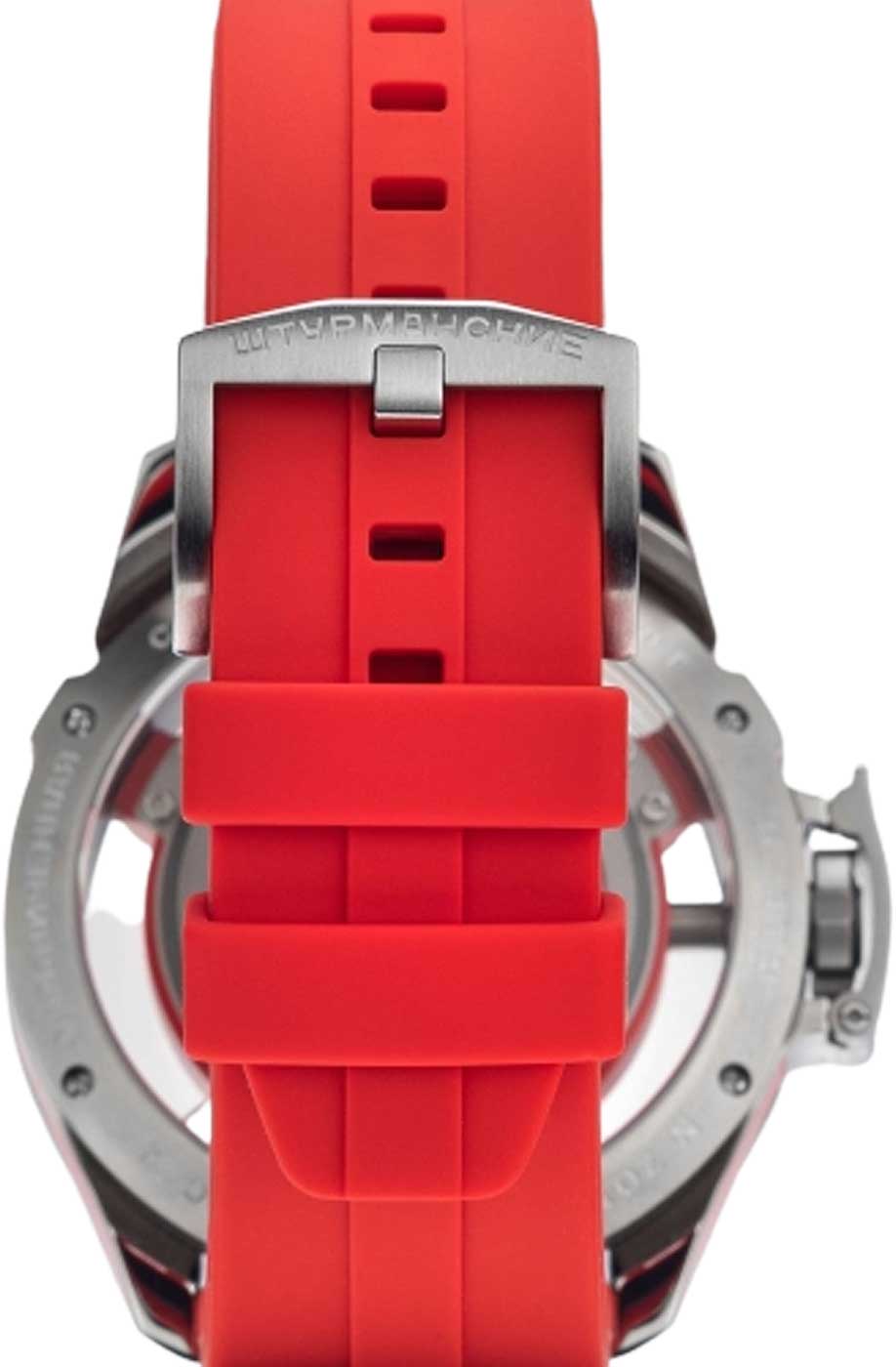 Ovanifrån på herrklocka med rött silikonarmband och spänne vid boetten