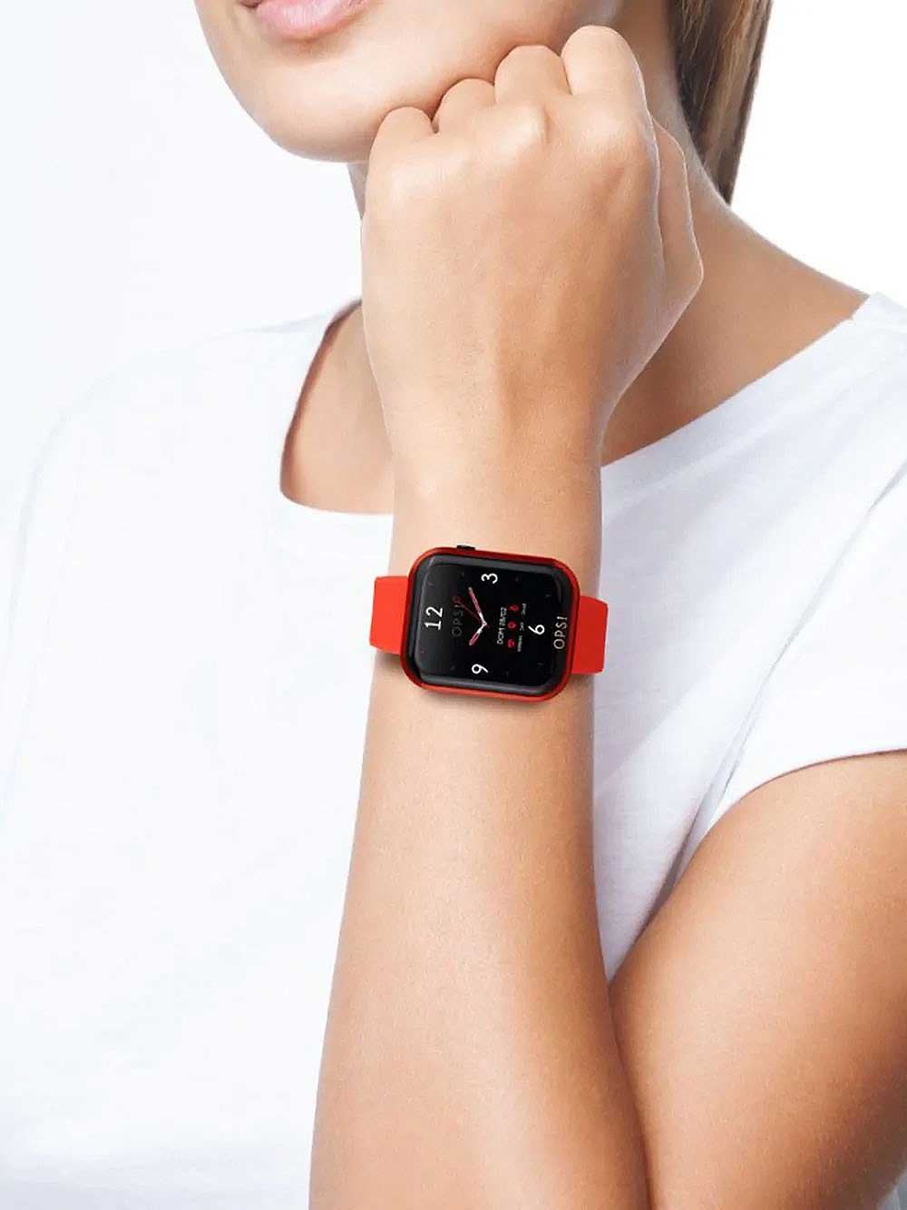Smartklocka med rött armband runt handleden, fyrkantig urtavla med siffror