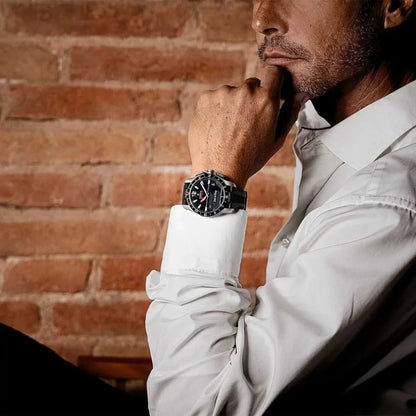 Armbandsur på en mans handled med svart urtavla och svart band