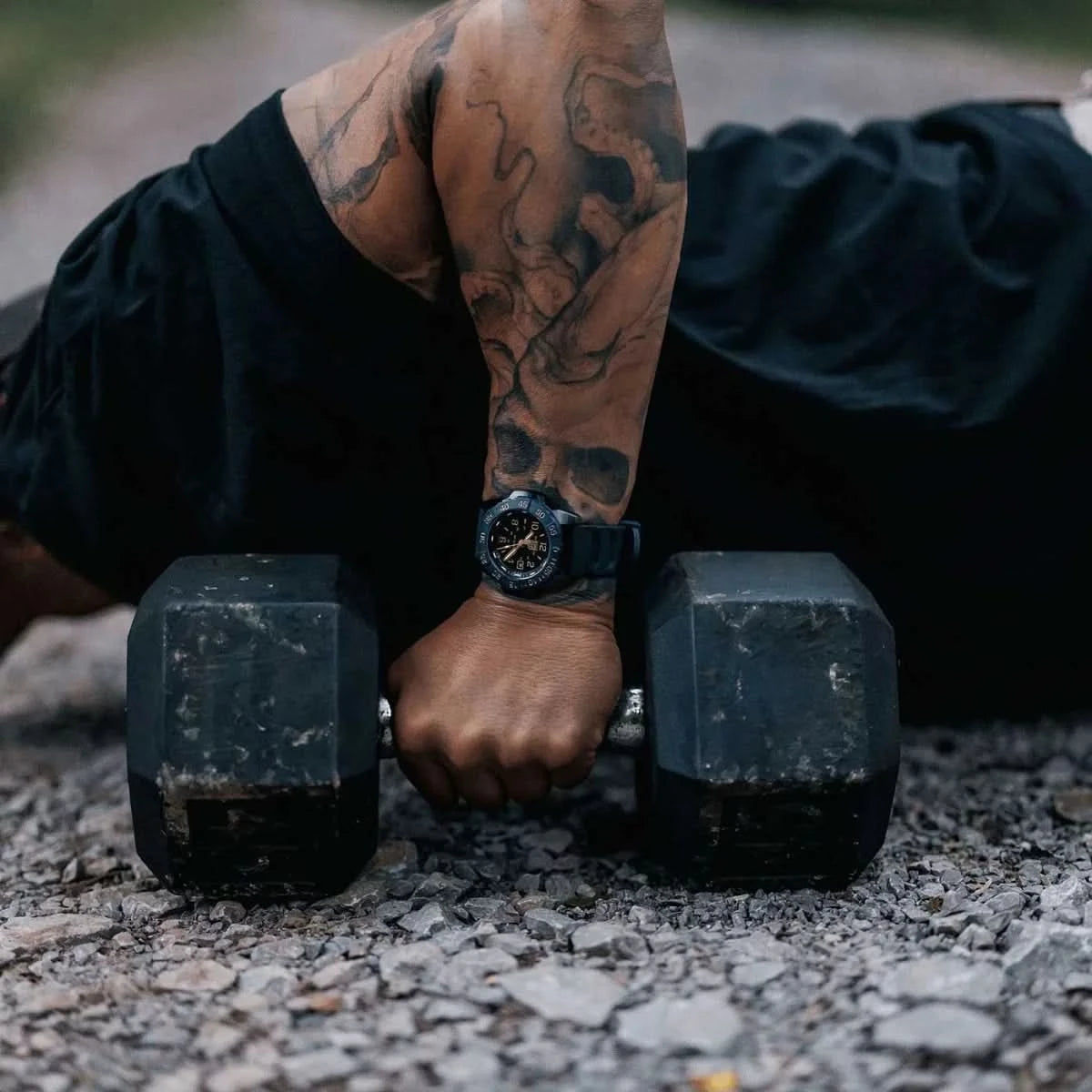 Herrklocka på handleden med mörkt armband och lättläst urtavla över hantlar.