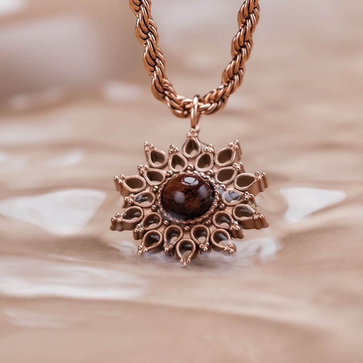 Halsband med roséguldpläterad kedja och solhänge med brun träcabochon och smyckesdetaljer