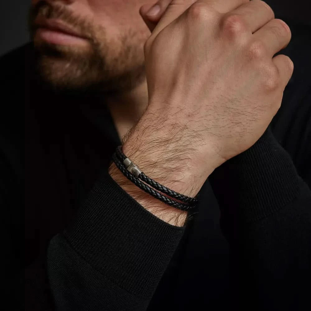 Armband av flätat mörkt läder på handleden