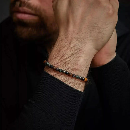Armband med mörka ädelstenspärlor och grått rostfritt stållås på handleden
