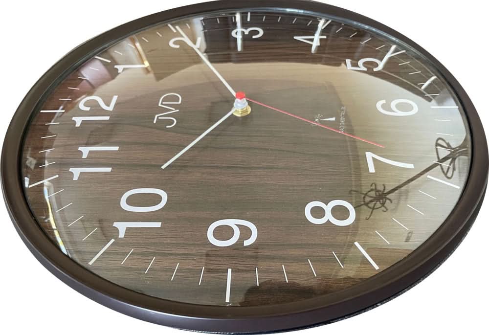 Rund väggklocka med träådring, mörk kant, siffrorna 1–12, röda och vita visare, JVD