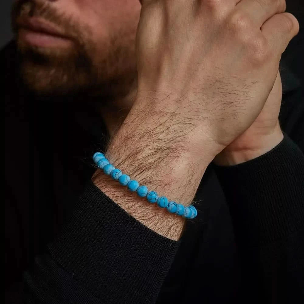 "Armband med turkosblå pärlor av turkrenit runt handleden"