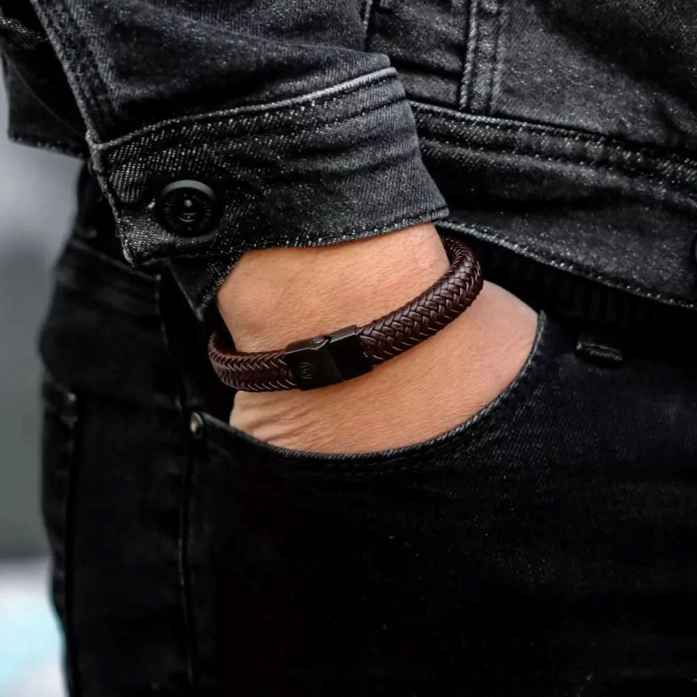 Läderarmband på handleden, mörkbrunt flätat, med svart rektangulärt lås