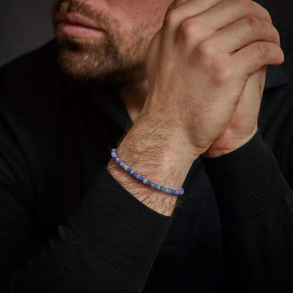 Armband av blåtonade skivpärlor i ädelsten på en handled