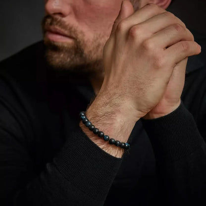 Armband av mörkblå tigeröga-pärlor på en mans handled
