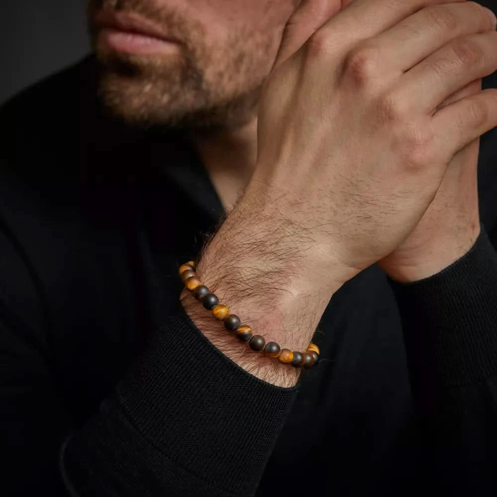 Armband med bruna och gyllene tigeröga-pärlor på handleden