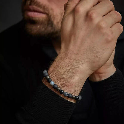 Armband på handleden med mörka stenpärlor och silverfärgade metallpärlor