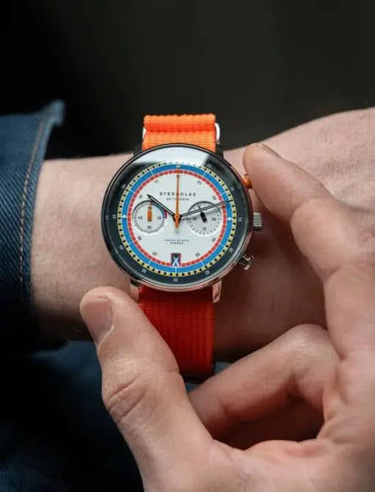 Herrklocka med orange textilarmband och flerfärgad urtavla