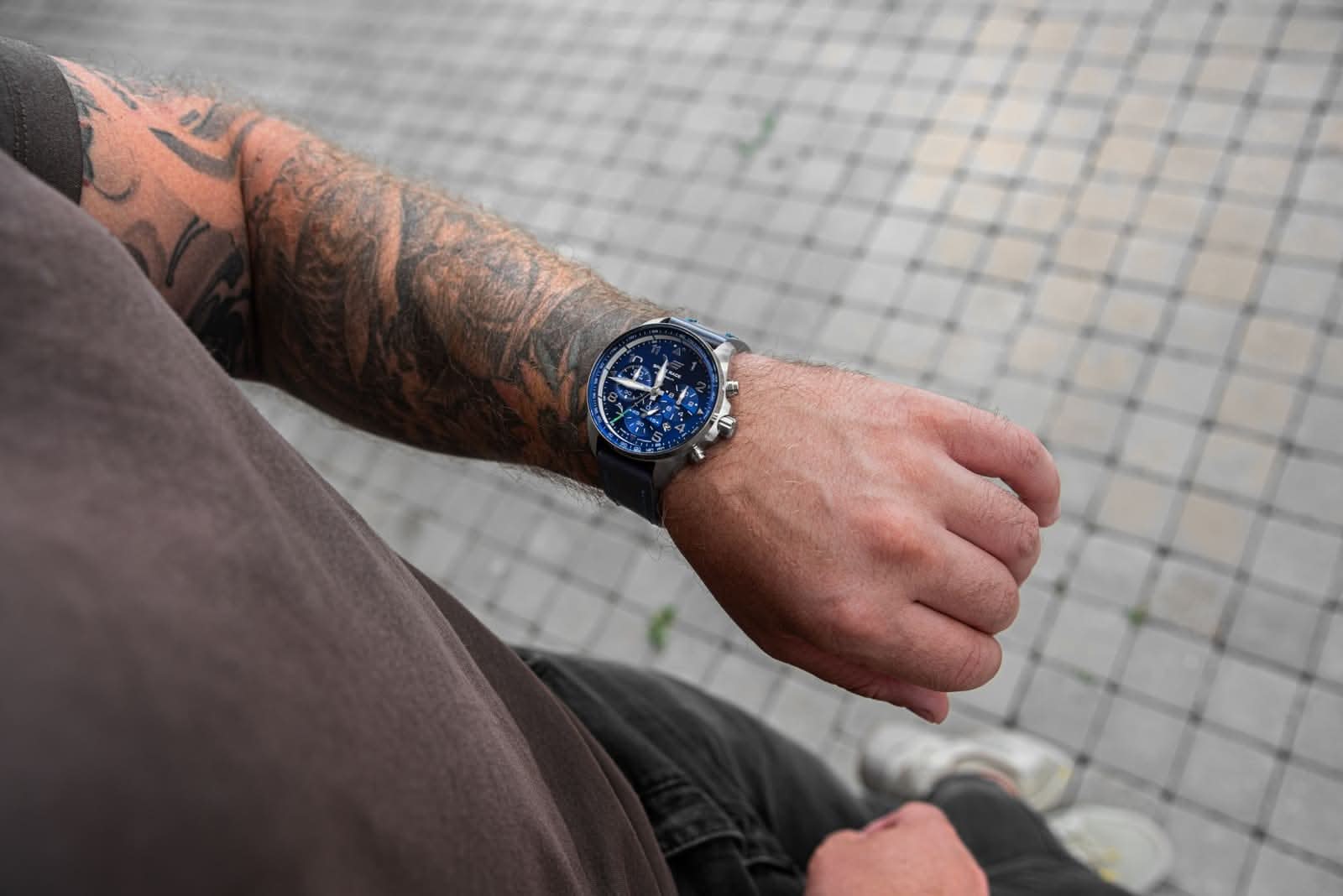 Herrklocka på handleden med blått läderarmband och blå urtavla