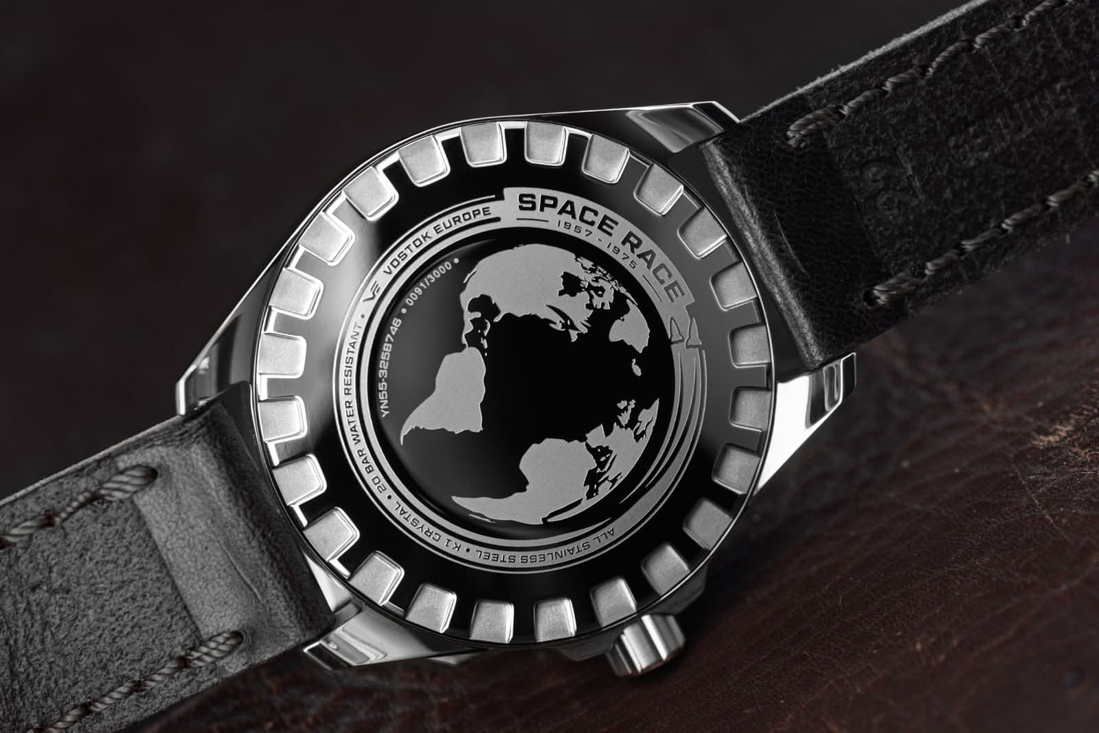 Klockfodral bakifrån med världskartmotiv i ringen och svart läderband