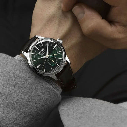 Seiko Presage herrklocka på handleden, mörkgrön urtavla, brunt läderband.