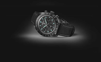 Seiko herrklocka med svart tygarmband och mörkgrön urtavla, kronograf, takymeter.
