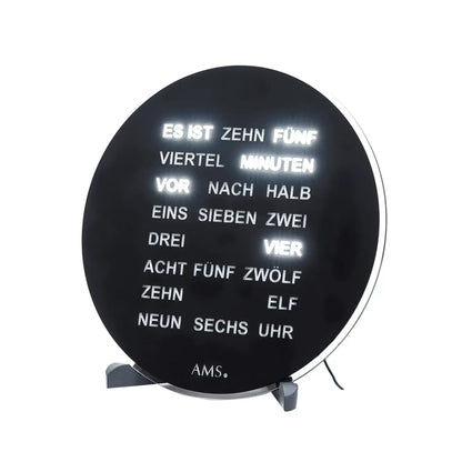 Schwarze runde AMS Uhr mit Textanzeigen auf dem Ziffernblatt und Stützfüßen