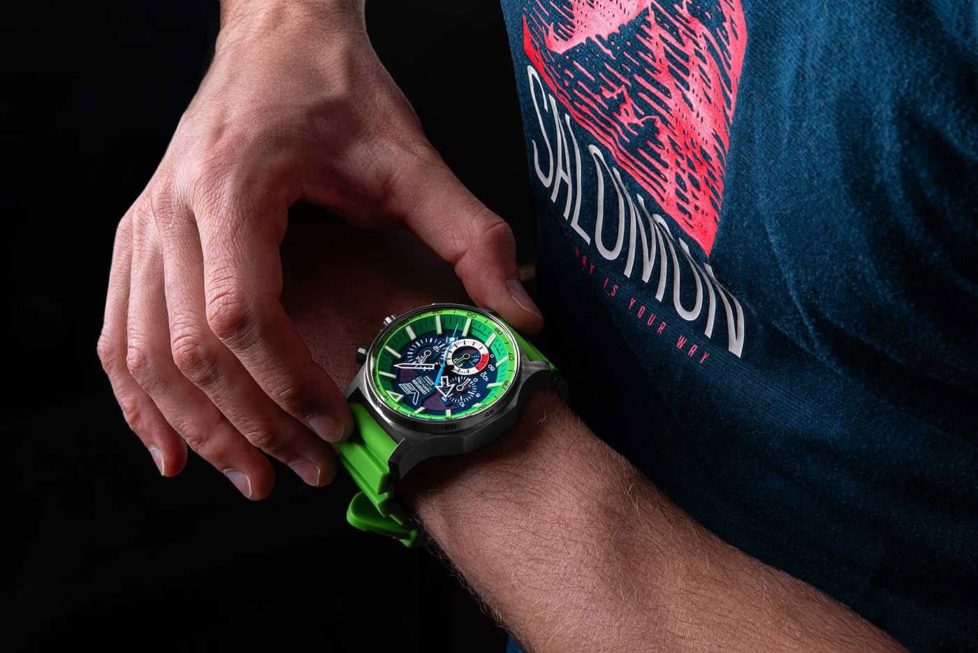 Herrklocka på handleden med grönt armband och självlysande urtavla