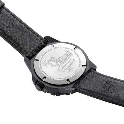 Herrklocka baksida: runt urverk med gravyr och svart läder-/textilarmband