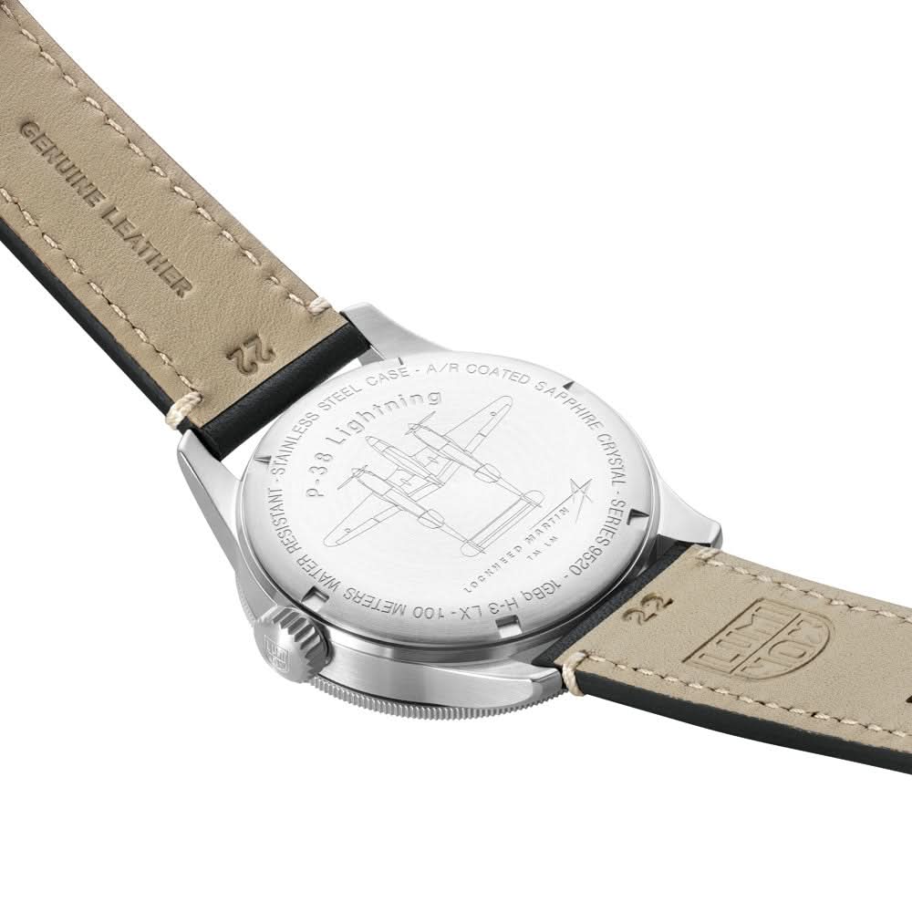 Herrarmbandsur med metallbaksida och beige läderarmband, undersidan i fokus.