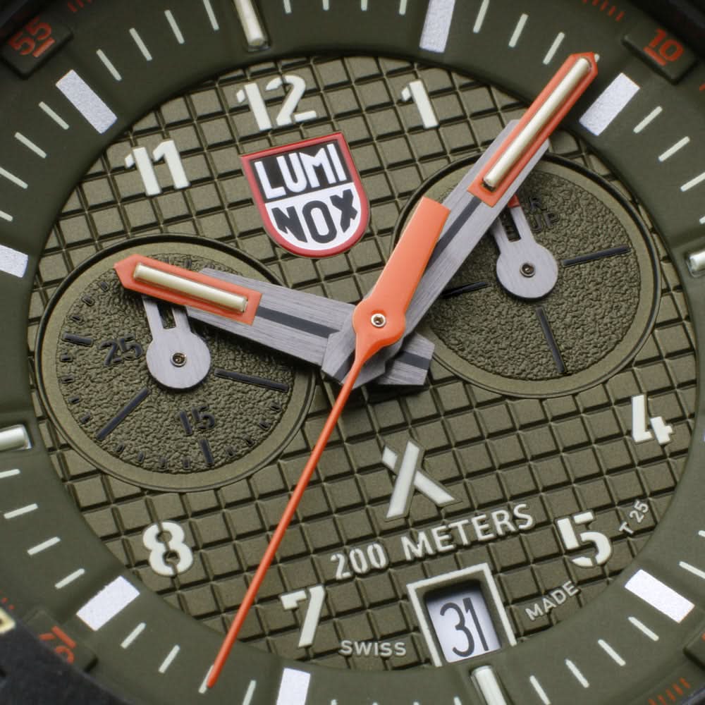 Herrklocka detaljer: orange visare, "LUMINOX"-logotyp och urtavla med 200 meters angivelse