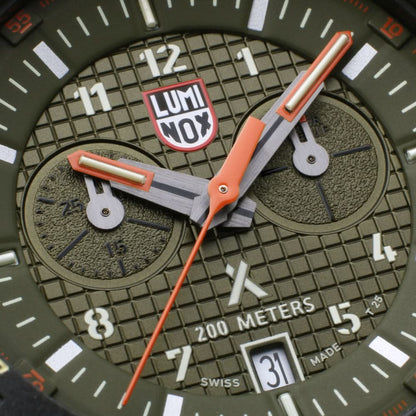 Herrklocka detaljer: orange visare, "LUMINOX"-logotyp och urtavla med 200 meters angivelse