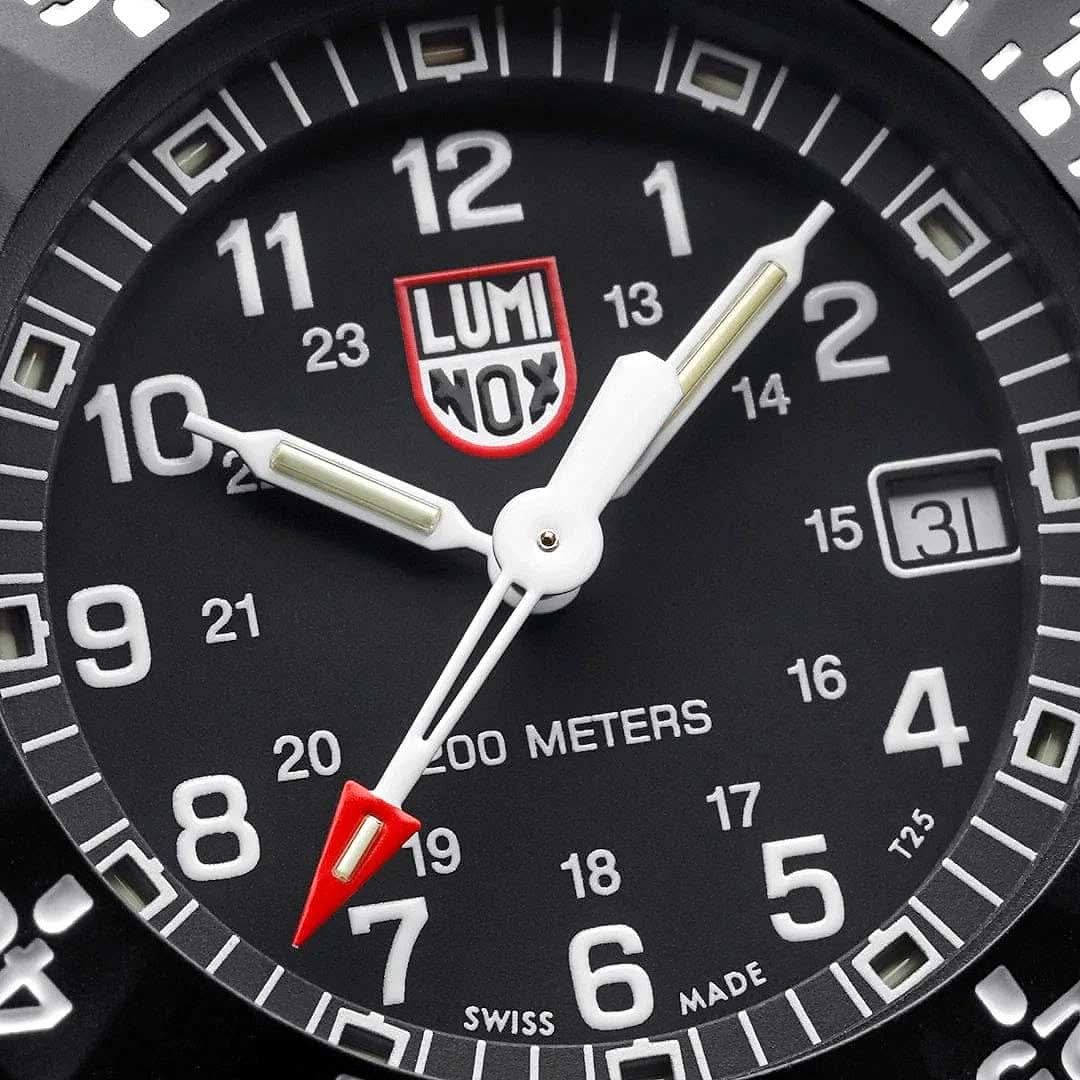 Sportklockans urtavla med LUMINOX-logotyp, vita siffror, lysande punkter och datumvisning