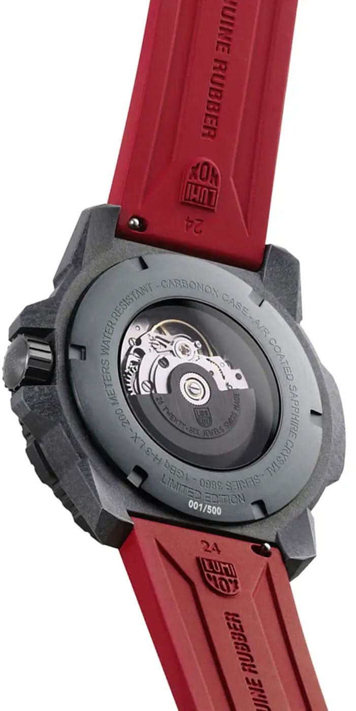 Baksida på automatisk klocka med rotor och rött armband, serienummer/modellinformation