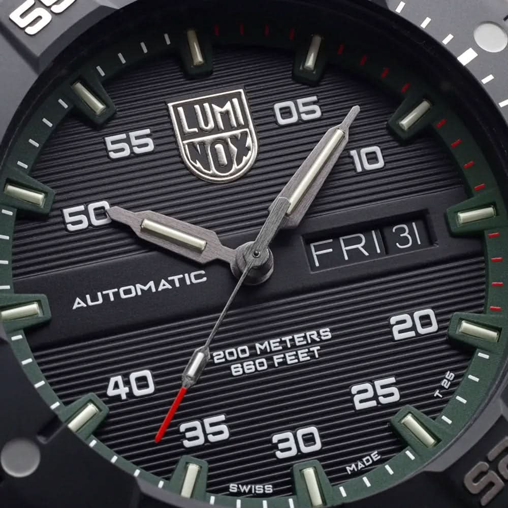 Närbild på urtavla: LUMINOX-logotyp, AUTOMATIC, FR/31 och skala upp till 200 meter; gröna accenter.