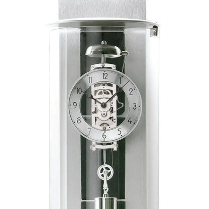 Väggklocka med synligt urverk i en transparent cylinder, urtavla och mekanik