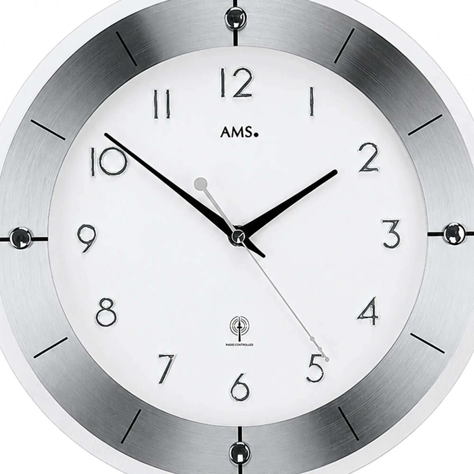 Nahaufnahme der Silber-Wanduhr: weißes Ziffernblatt mit schwarzen Zeigern und arabischen Ziffern