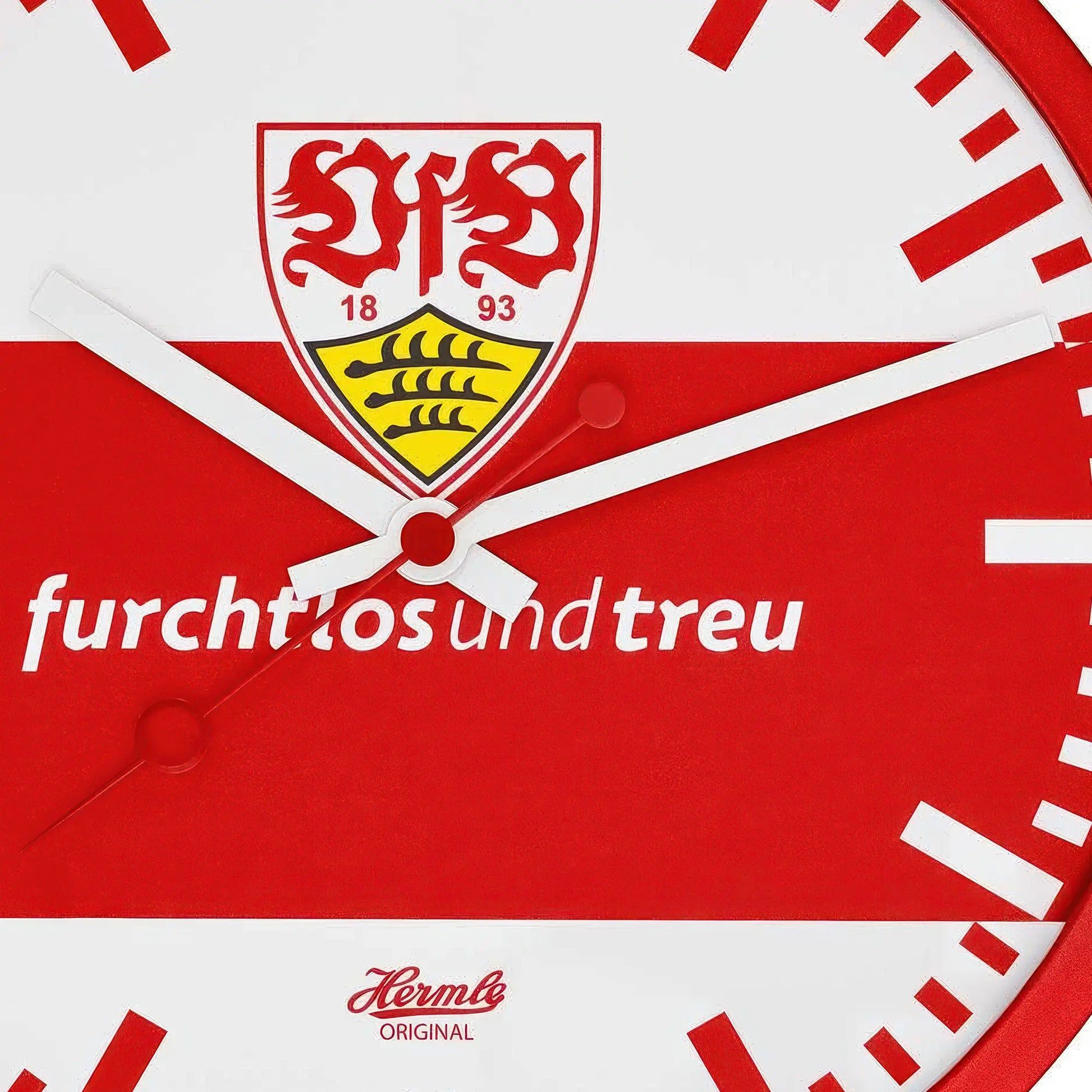 Närbild: rund väggklocka med röd urtavla, vit kant och VfB-emblem