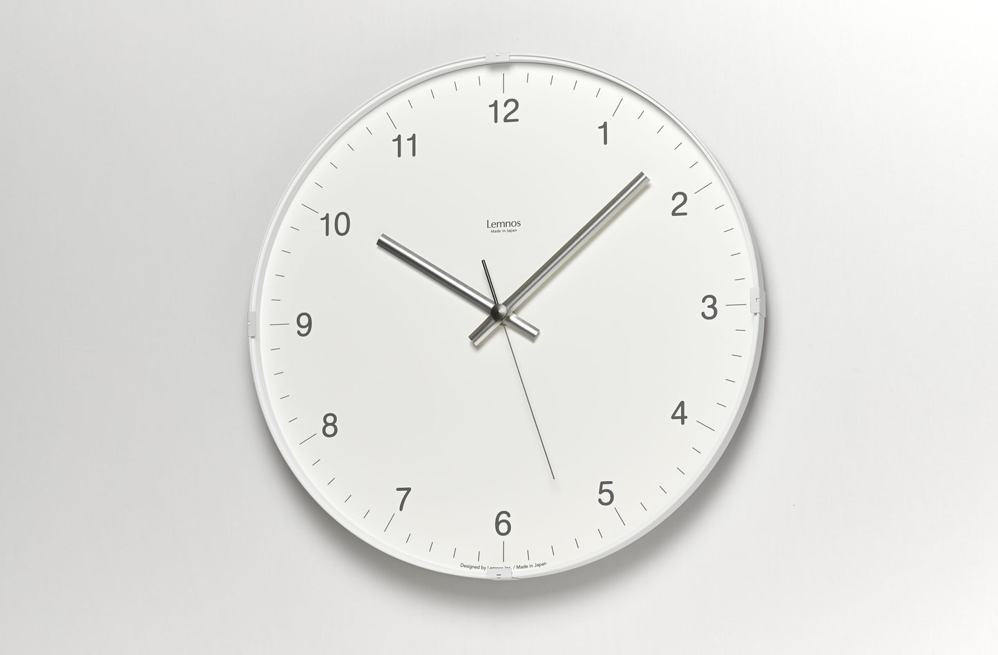 Runde Wanduhr mit weißem Zifferblatt, Zahlen 12–6 und drei Zeigern
