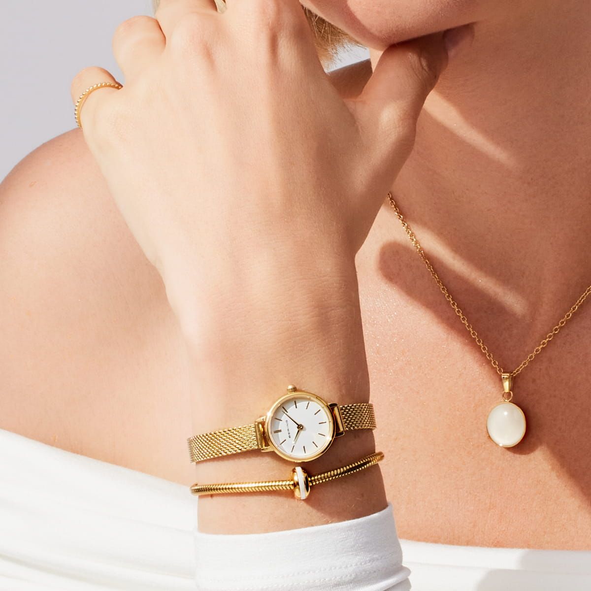 Zegarek damski z okrągłą białą tarczą i złotą bransoletą typu mesh