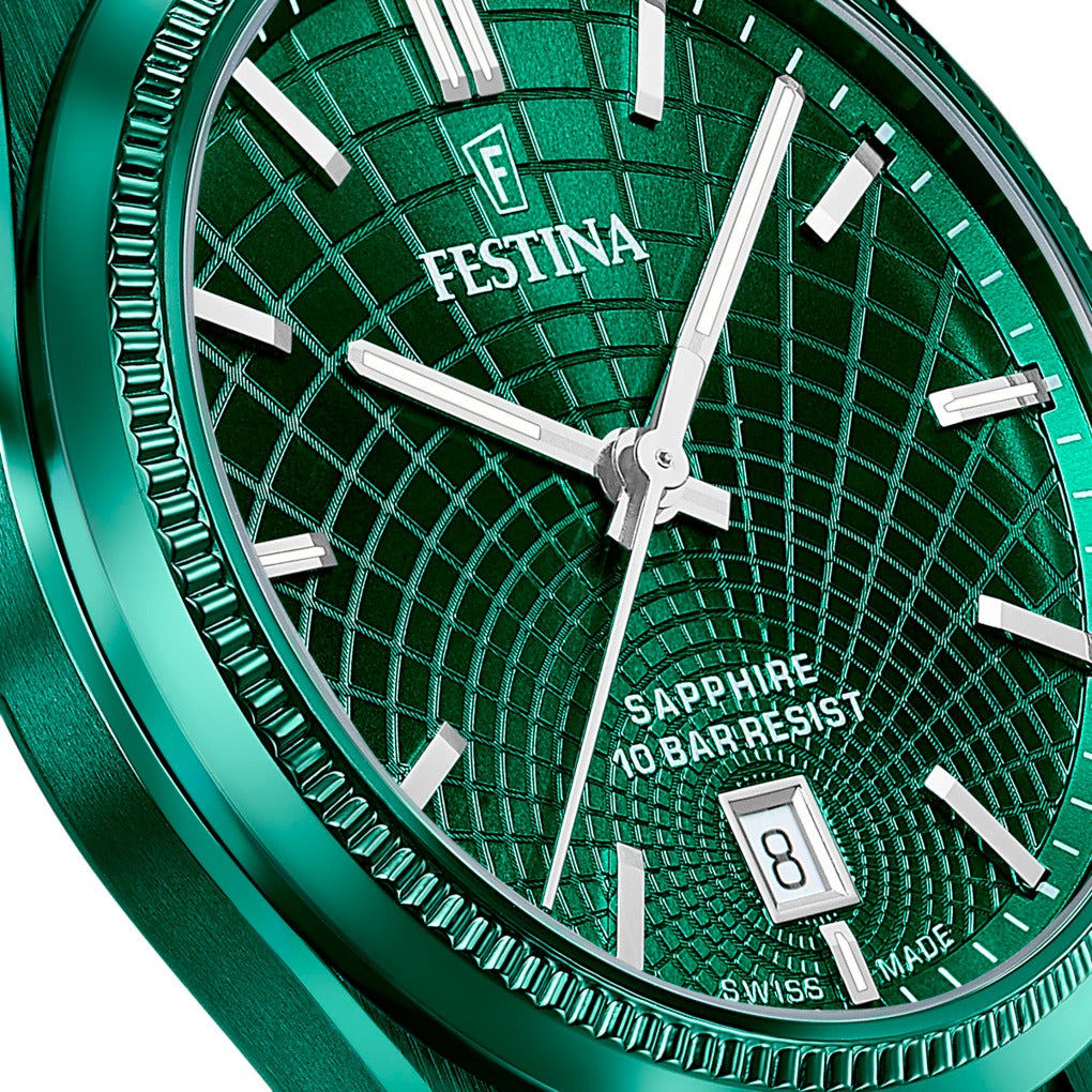 Zbliżenie na zieloną tarczę z kratkowaną strukturą, srebrnymi wskazówkami i logo FESTINA