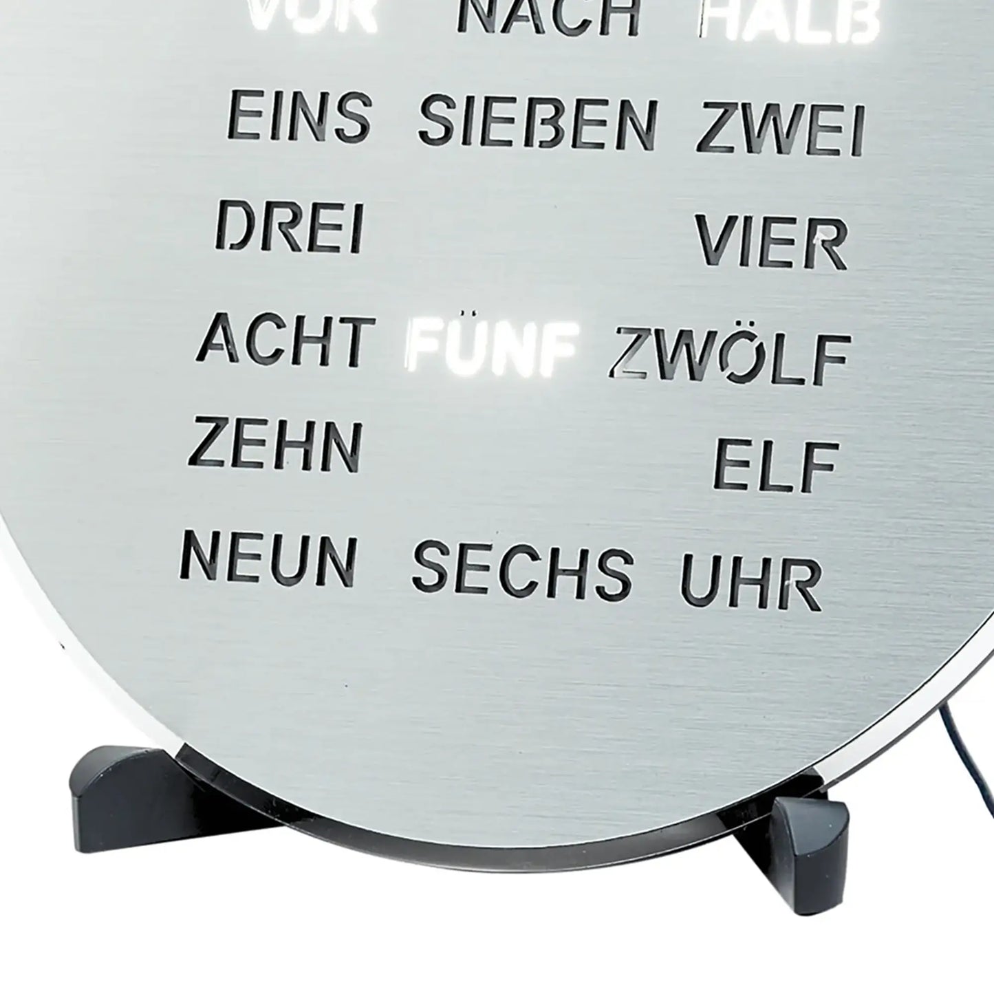 Primo piano del display testuale a LED sul quadrante grigio dell'orologio con il testo "uno sette due quattro"