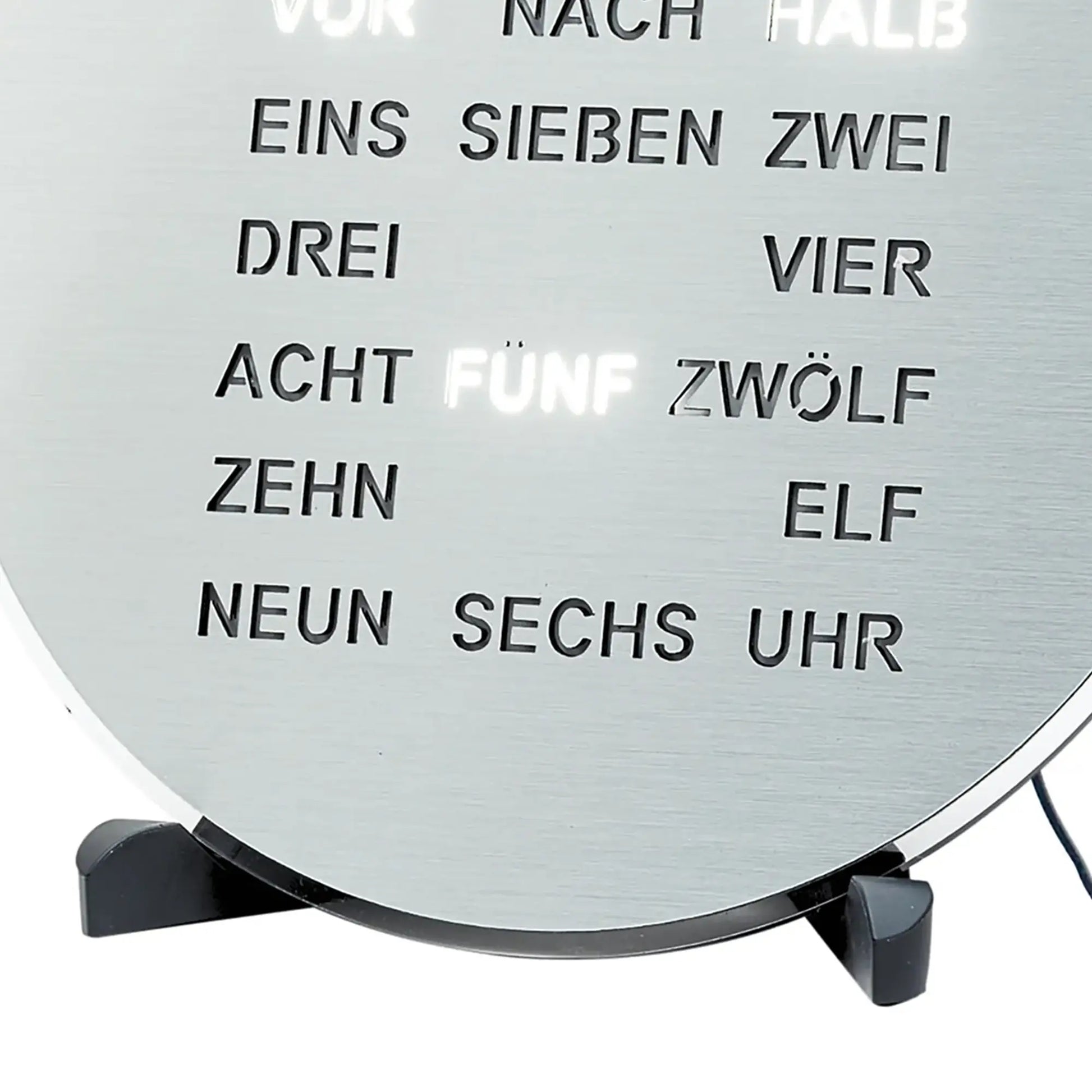 Primo piano del display testuale a LED sul quadrante grigio dell'orologio con il testo "uno sette due quattro"