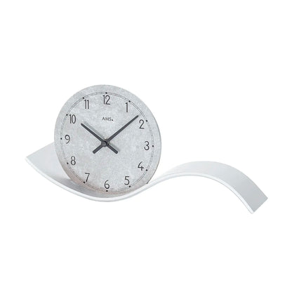 Orologio da tavolo in vista a tre quarti: quadrante grigio, lancette nere e base curva argentata