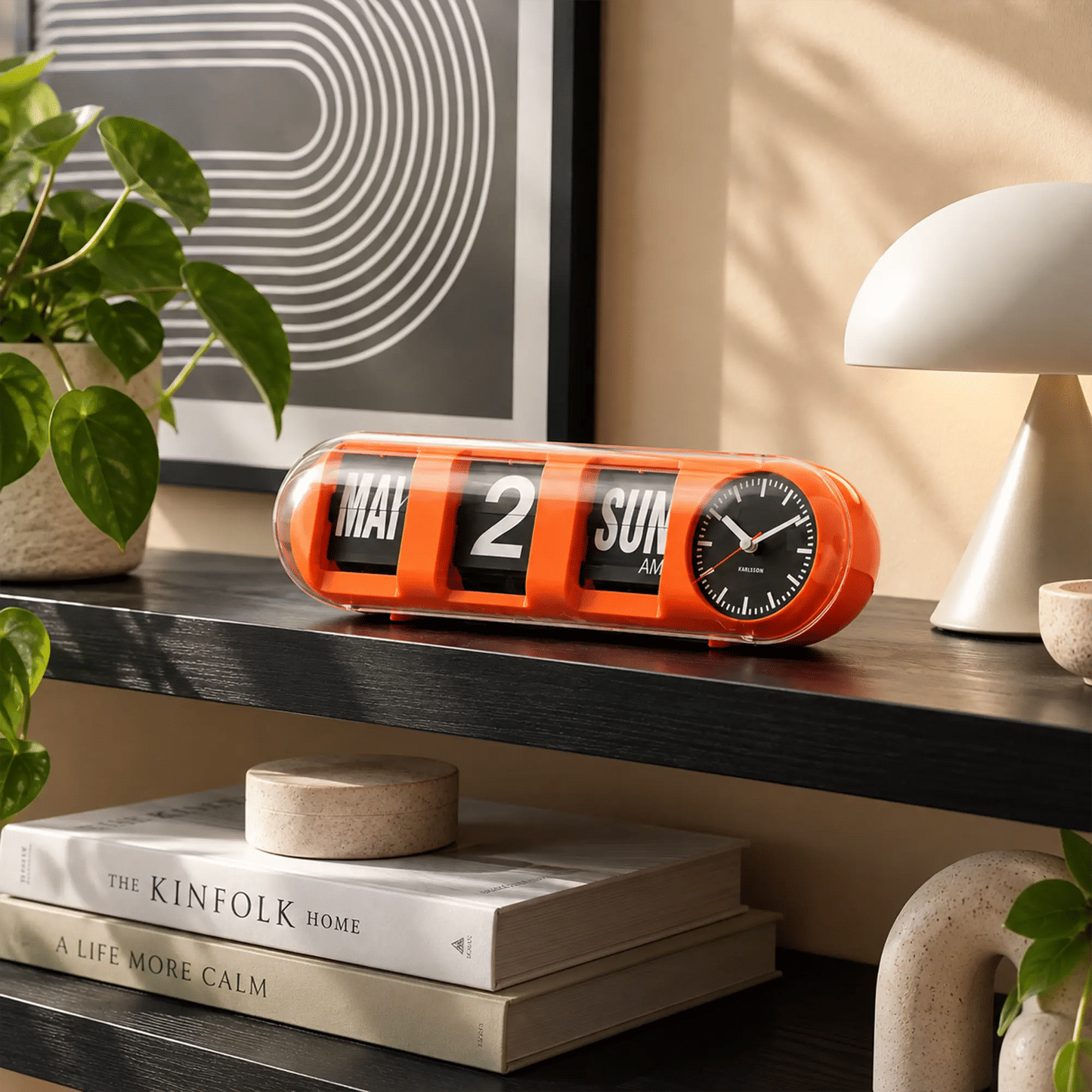 Orange Tisch-Wanduhr mit Klappzahlen (MAY, 2, SUN AM) und Rundzifferblatt an der Seite