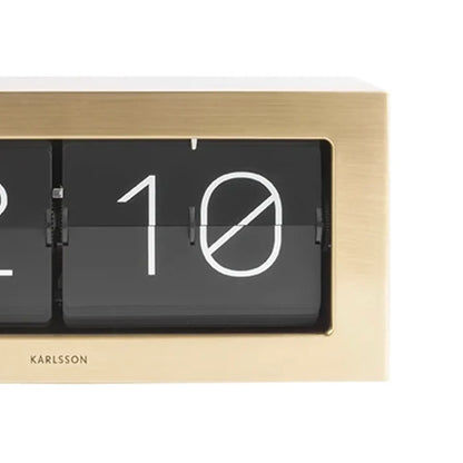 Karlsson Flip-Uhr: schwarzes Ziffernfenster mit großen Klappzahlen, goldfarbenes Rahmengehäuse
