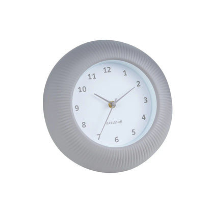 Warmgraue Wanduhr mit geriffeltem Gehäuse, weißem Zifferblatt und goldenen Zeigern