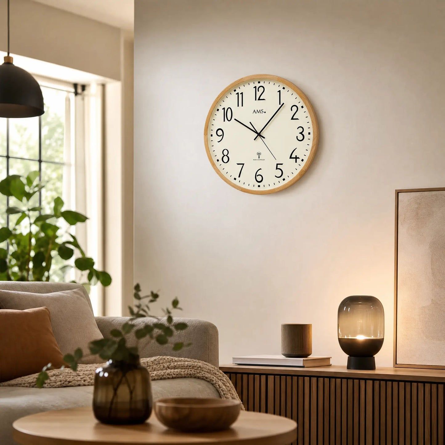 Orologio da parete su una parete sopra mobili da soggiorno, quadrante beige con lancette nere in cornice di legno.