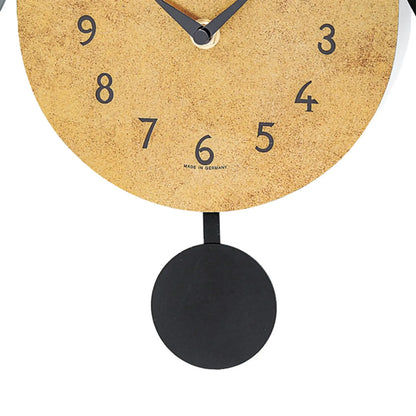 Vista ravvicinata del quadrante e del peso del pendolo dell'orologio a cucù, con numeri blu e sfondo dorato