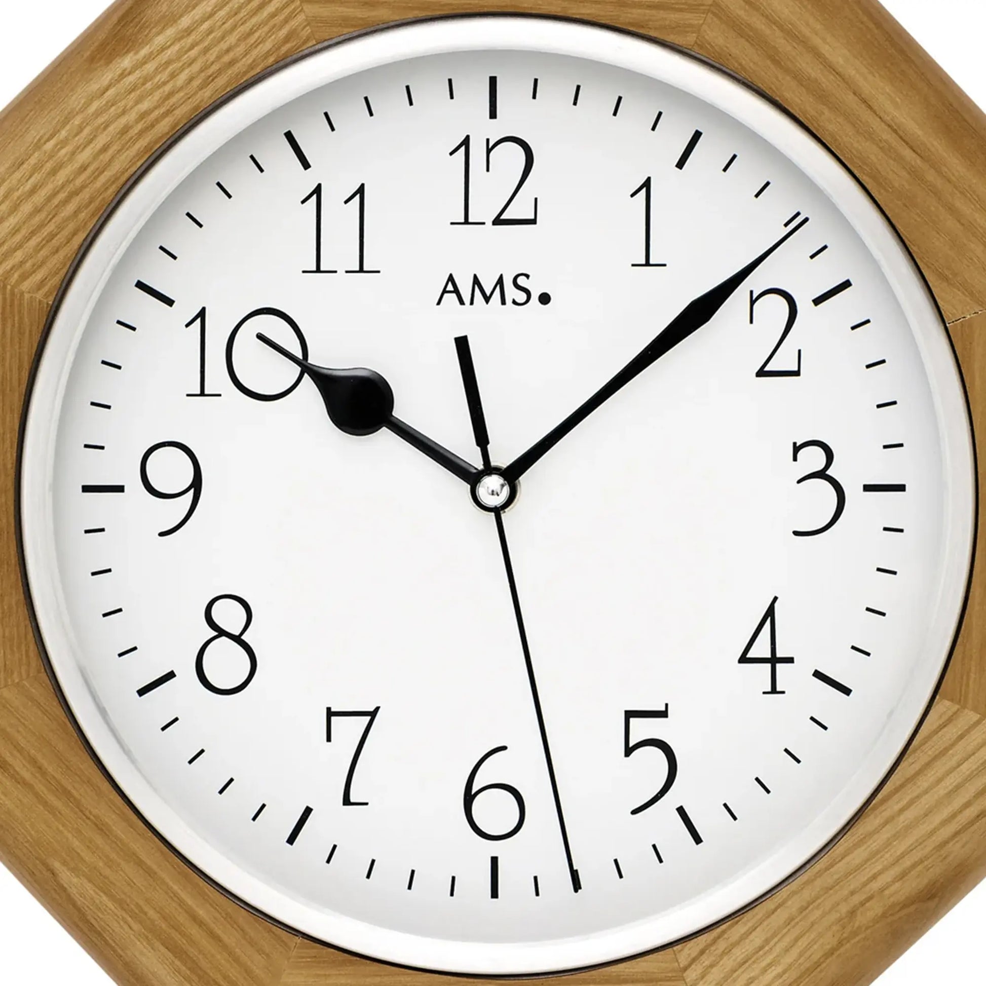 Nahaufnahme Wanduhr: Eichenholzrahmen, weißes Zifferblatt mit AMS und schwarzen Zeigern